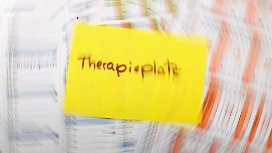 Zettel mit dem Schriftzug «Therapieplatz» liegt auf Kalendern