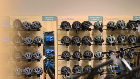Regalwand mit verschiedenen Fahrradhelmen für Jugend, Trekking und MTB im Fachgeschäft.