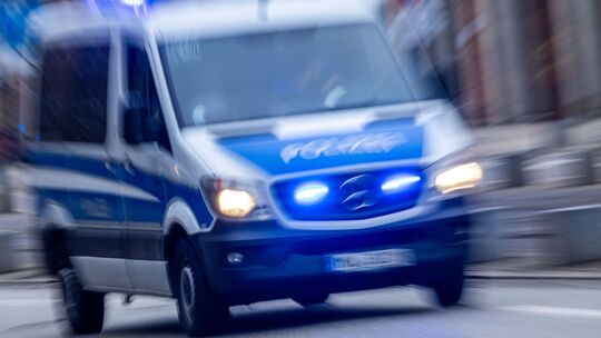Einsatzfahrzeug der Polizei fährt mit Blaulicht durch Innenstadt