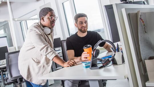Zwei Kollegen arbeiten gemeinsam in einem Büro