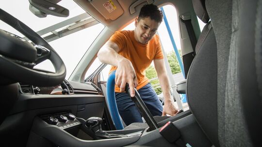 Mann saugt den Innenraum seines Autos