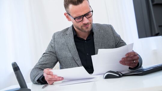Ein Mann sieht im Büro in Unterlagen