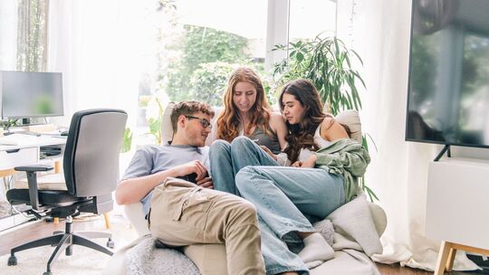 Jugendliche blicken gemeinsam auf ein Smartphone