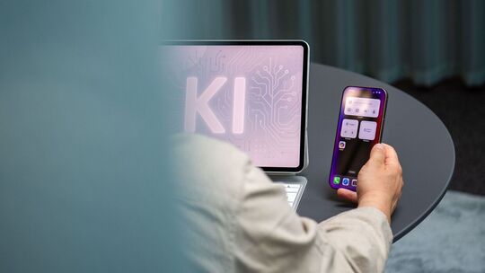 Ein Mann nutzt einen KI-Assistenten auf einem iPad und iPhone