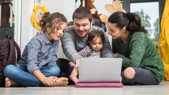 Eine Familie plant ihren Urlaub am Laptop