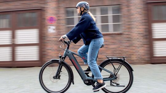 Eine junge Frau fährt auf einem E-Trekkingbike