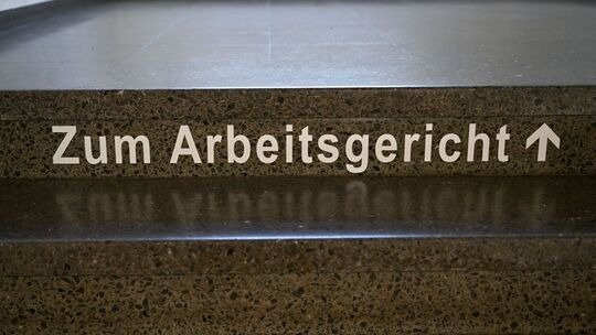 Schriftzug «Zum Arbeitsgericht» auf einer Treppenstufe