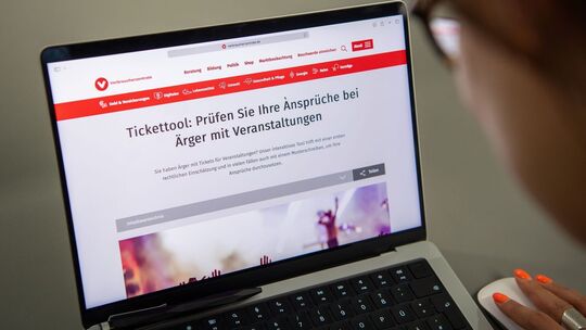 Eine Frau nutzt die Tickettool-Webseite der Verbraucherzentrale