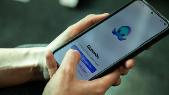 Eine Frau nutzt die App Openvibe auf dem Smartphone