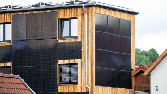 Eine Hauswand ist mit Solarpanels verkleidet