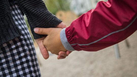 Eine Mutter hält die Hand ihres Kindes Eine Mutter hält die Hand ihres Kindes