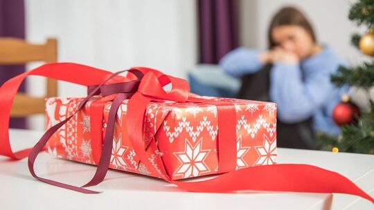 Ein Geschenk auf dem Tisch - eine Frau im Hintergrund