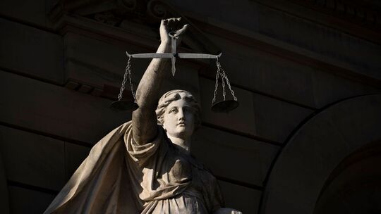 Vor einem Justizgebäude steht die Statue der Justitia Vor einem Justizgebäude steht die Statue der Justitia