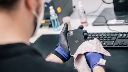 Ein Mitarbeiter überprüft ein refurbished Iphone