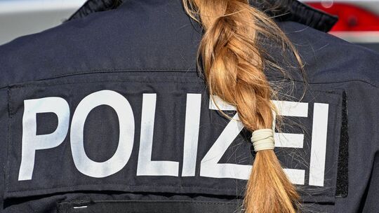 Der Zopf einer Polizistin hängt über ihre Uniform.