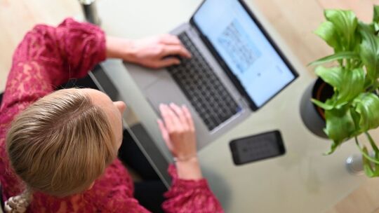 Eine Frau sitzt zuhause an einem Laptop Eine Frau sitzt zuhause an einem Laptop