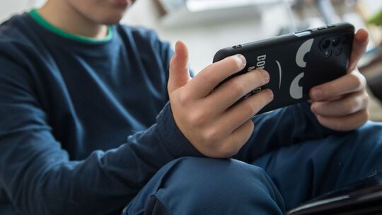 Junge schaut auf sein Smartphone