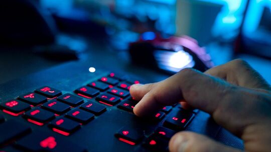 Ein Mann sitzt am Rechner und tippt auf einer Tastatur Ein Mann sitzt am Rechner und tippt auf einer Tastatur