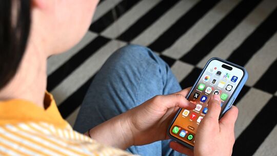 Eine Jugendliche sitzt am Smartphone (Archivbild)