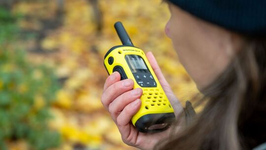 Eine Frau spricht in ein Walkie-Talkie in ihrer Hand
