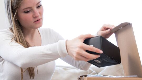 Eine Frau öffnet ein Paket Eine Frau öffnet ein Paket