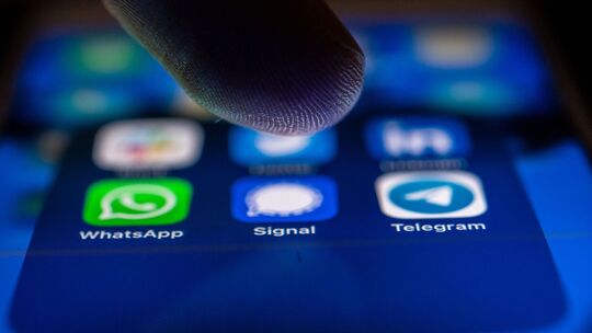 Ein Finger schwebt über dem Icon der Signal-App
