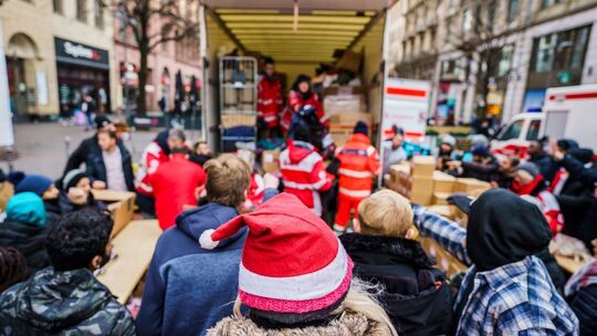 Ehrenamtliche Helfer verteilen Spenden an Bedürftige