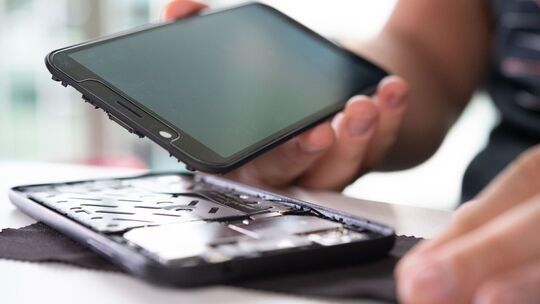 Mann baut ein Smartphone auseinander