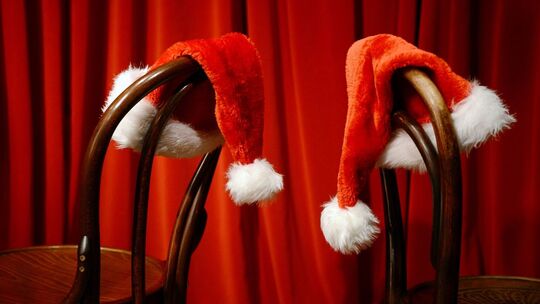 Weihnachtsmützen hängen über Stühlen Weihnachtsmützen hängen über Stühlen