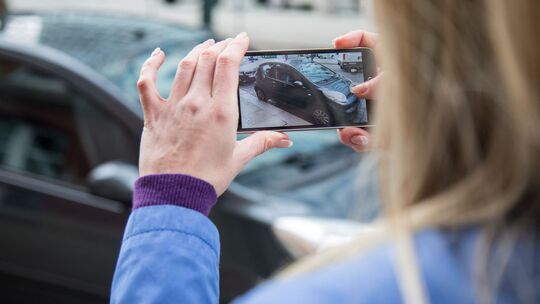 Frau fotografiert ein Auto