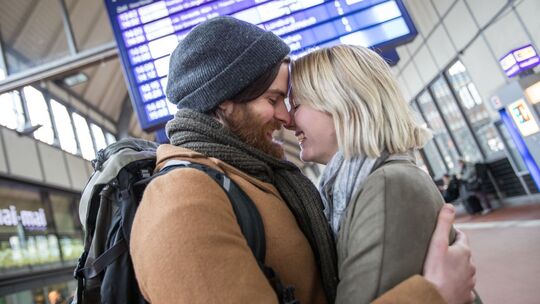 Ein Paar umarmt sich am Bahnhof