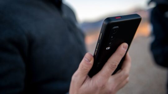 Ein Mann hält ein Smartphone in der Hand