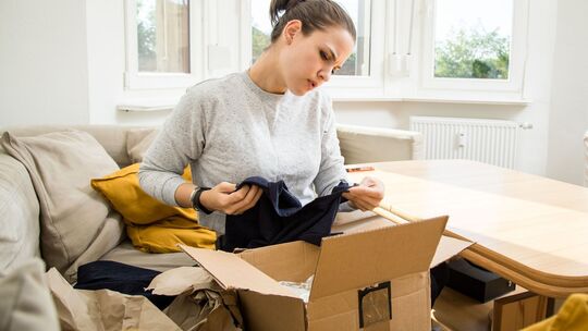 Frau prüft kritisch die Lieferung der online bestellten Ware