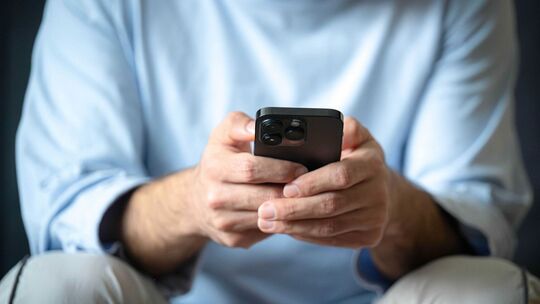 Ein Mann tippt auf einem Smartphone