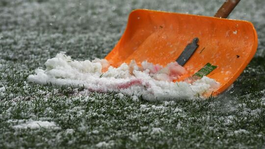 Schneeschaufel auf Fußballplatz Schneeschaufel auf Fußballplatz