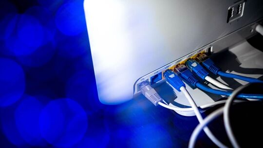 Zahlreiche Netzwerkkabel stecken in einem Router