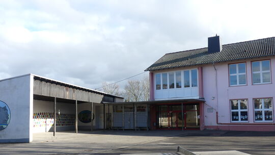 Am Grundschulgebäude in Rümmelsheim soll an Stelle des Unterstandes (links) ein neuer, größerer Anbau errichtet werden. Im Haush