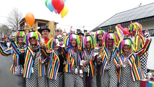 Fantasievoller und farbenfroher Kopfschmuck mit einem schicken Overall zeichnet diese illustre Gruppe aus.