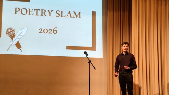 Moderator Lennart Schmitt führt in den Abend der Gedichte ein. Neben ihm das Mikrophon für die oftmals aufgeregten Schüler
