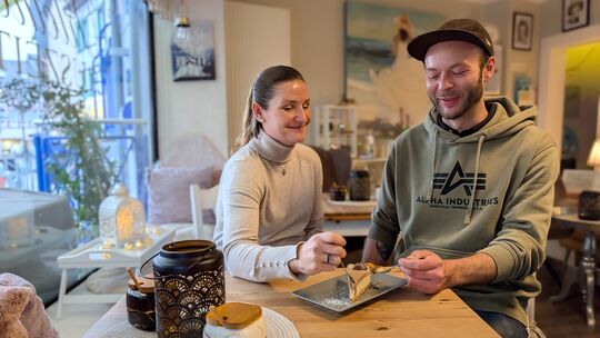 Natascha Nowakowski und Tobi von der Kleinen Auszeit in Adenau mit einer Cheesecake-Kreation mit Kinderriegeln.
