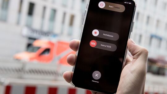 Mann bedient Funktion «Notruf SOS» auf seinem iPhone Mann bedient Funktion «Notruf SOS» auf seinem iPhone