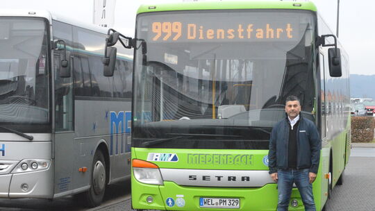 Telli Celik steht vor einem Bus der Firma Medenbach, in dem er unter anderem viele Schulkinder transportiert.