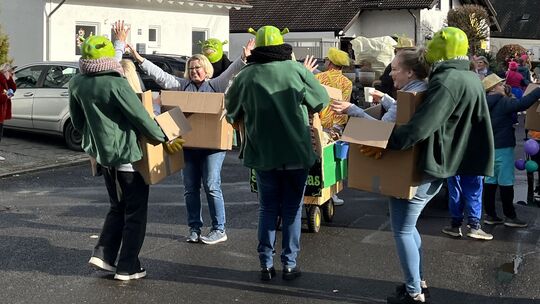 Tanzende Oger tragen gut gelaunte Damen auf dem Möhnenumzug in Rhens mit sich herum.