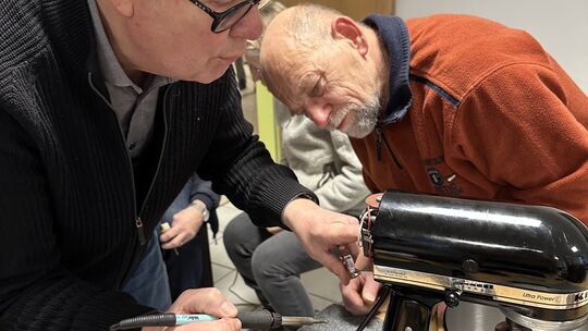 Günter Maier und Eberhard Fietz beim Löten der Elektronik einer Küchenmaschine.