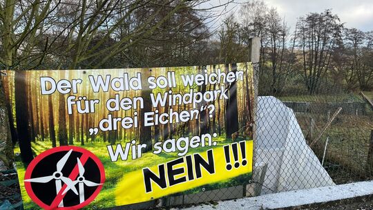 Auf einem Plakat in Quirnbach wird Kritik am geplanten Windpark geübt.