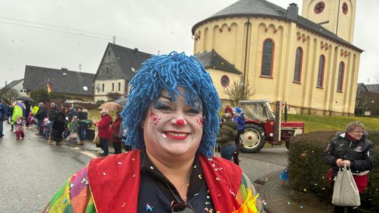 Diese Clown-Dame trotzt dem grauen Wetter mit ihrem Strahlen, ihrem bunten Kostüm und eine Extra-Portion Konfetti.
