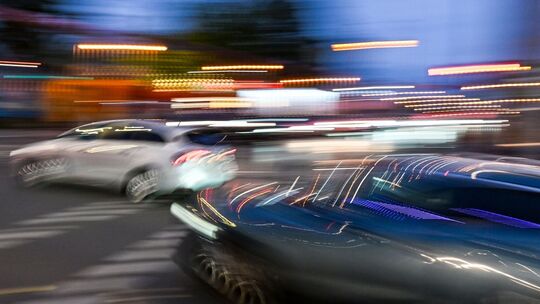 Autos fahren am Abend auf einer Kreuzung