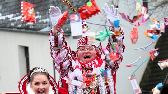 Prinzessin Silke und Prinz Achim sorgen beim Zug in Verscheid von ihrem Wagen aus für einen ergiebigen Kamelle-Regen.