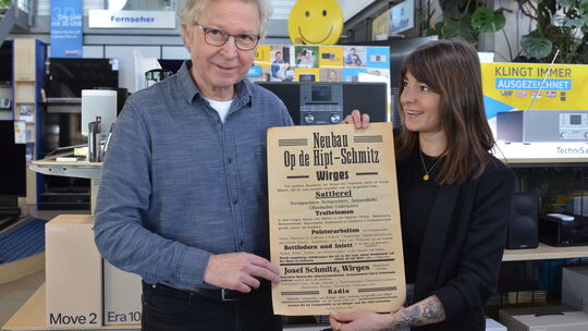 Stolz sind Rainer Quirmbach und seine Tochter Teresa Bach auf das Plakat, das aus der Zeit der Firmengründung des Wirgeser Tradi