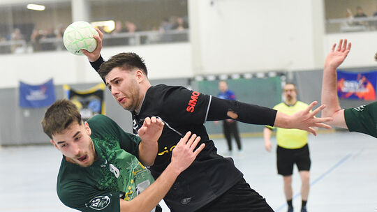 Auch in Schräglage behält Philip Gehres (schwarzes Trikot) das Tor im Visier. Mit seiner HSG Nahe-Glan möchte er auch am Samstag